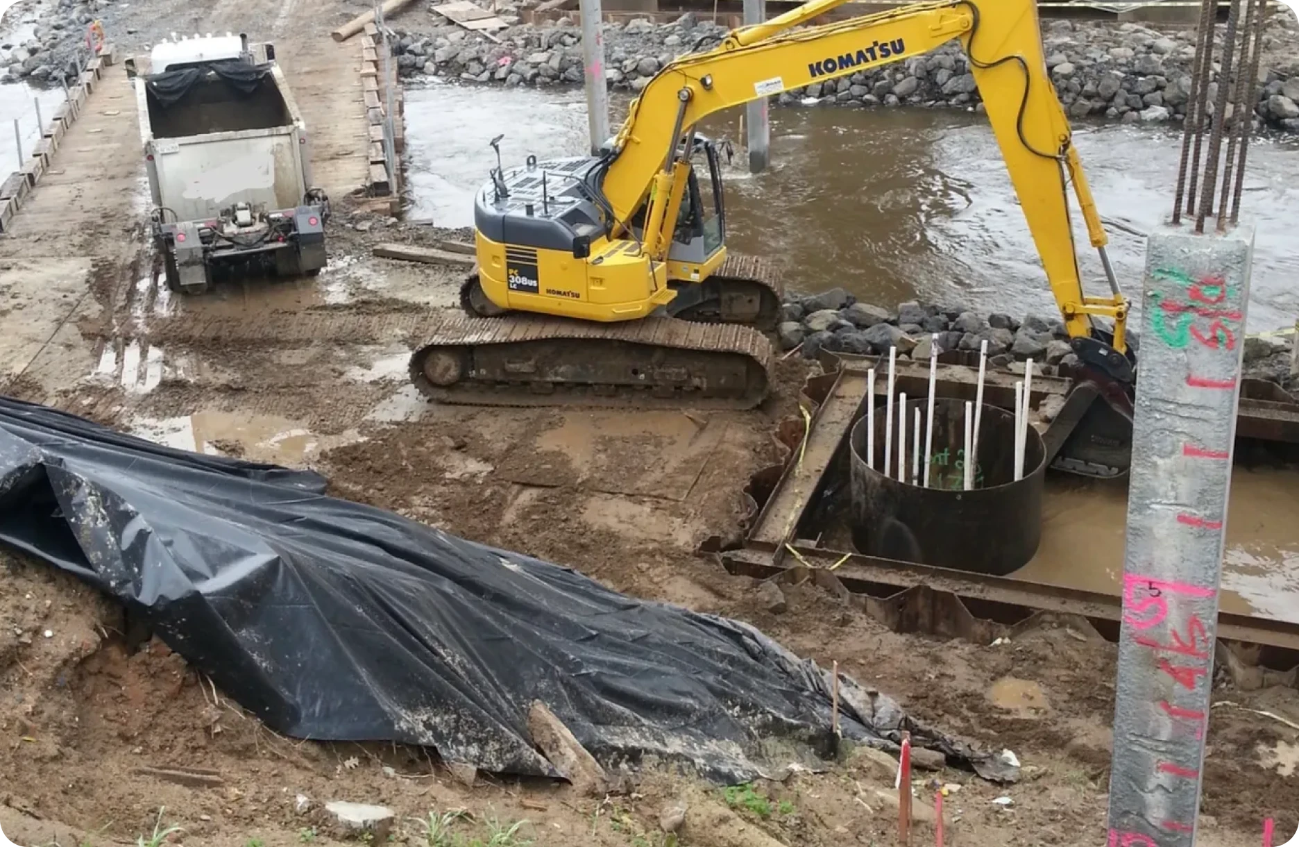 Excavator working at muddy construction site.