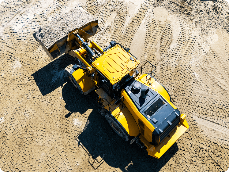 Yellow bulldozer moving sand on construction site.